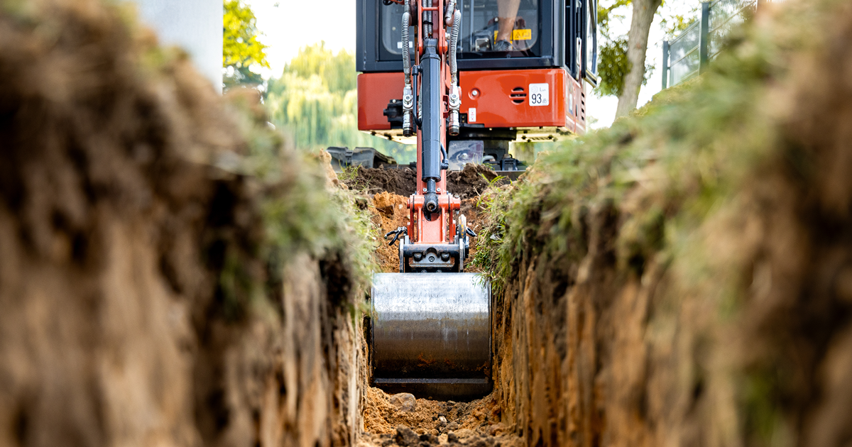 Excavation work exposing water and utility lines near a building