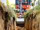 Travaux d’excavation mettant à découvert des conduites d’eau et des services publics près d’un bâtiment